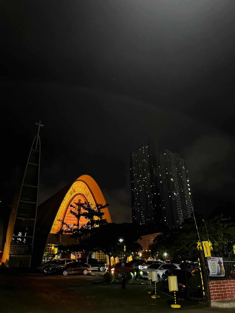 Arched stained-glass facade of Redemptorist Church glowing at night